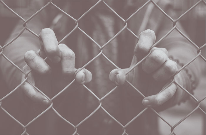 Hands holding fence