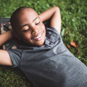Young boy laying on grass