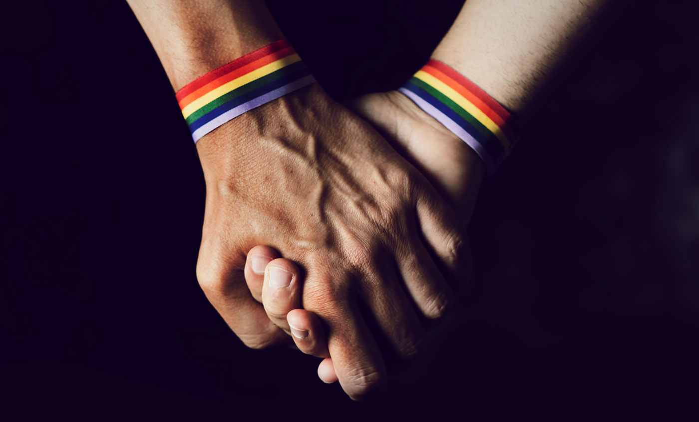 Holding hands with rainbow wristbands